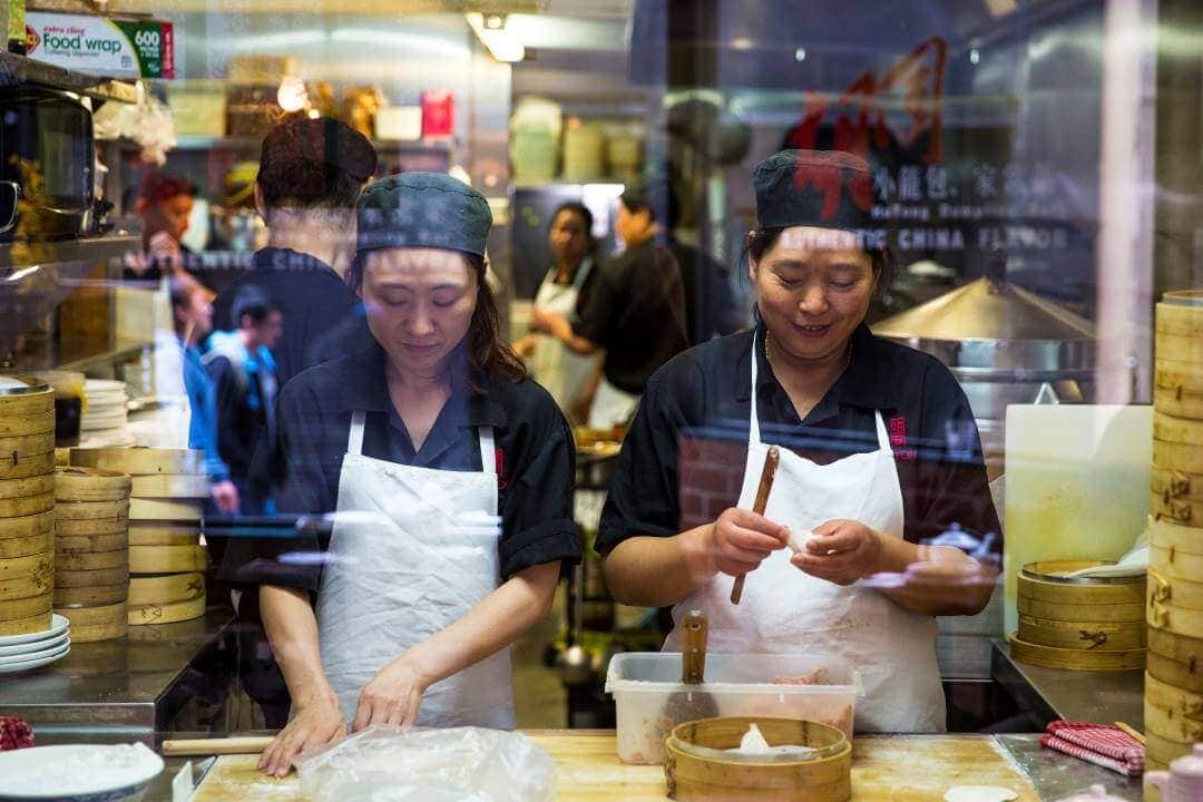 Workers making dumplings in window.