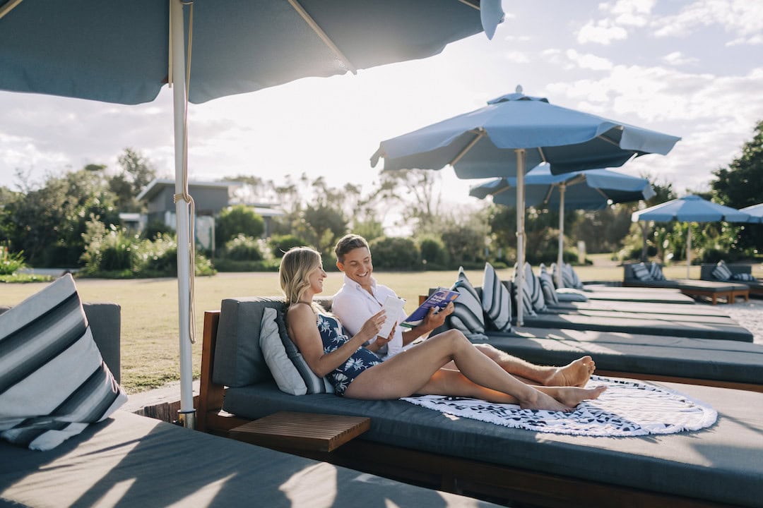 Couple relaxing at the Botanica Beach Club, exclusive to guests staying at Elements of Byron Resort, Byron Bay.