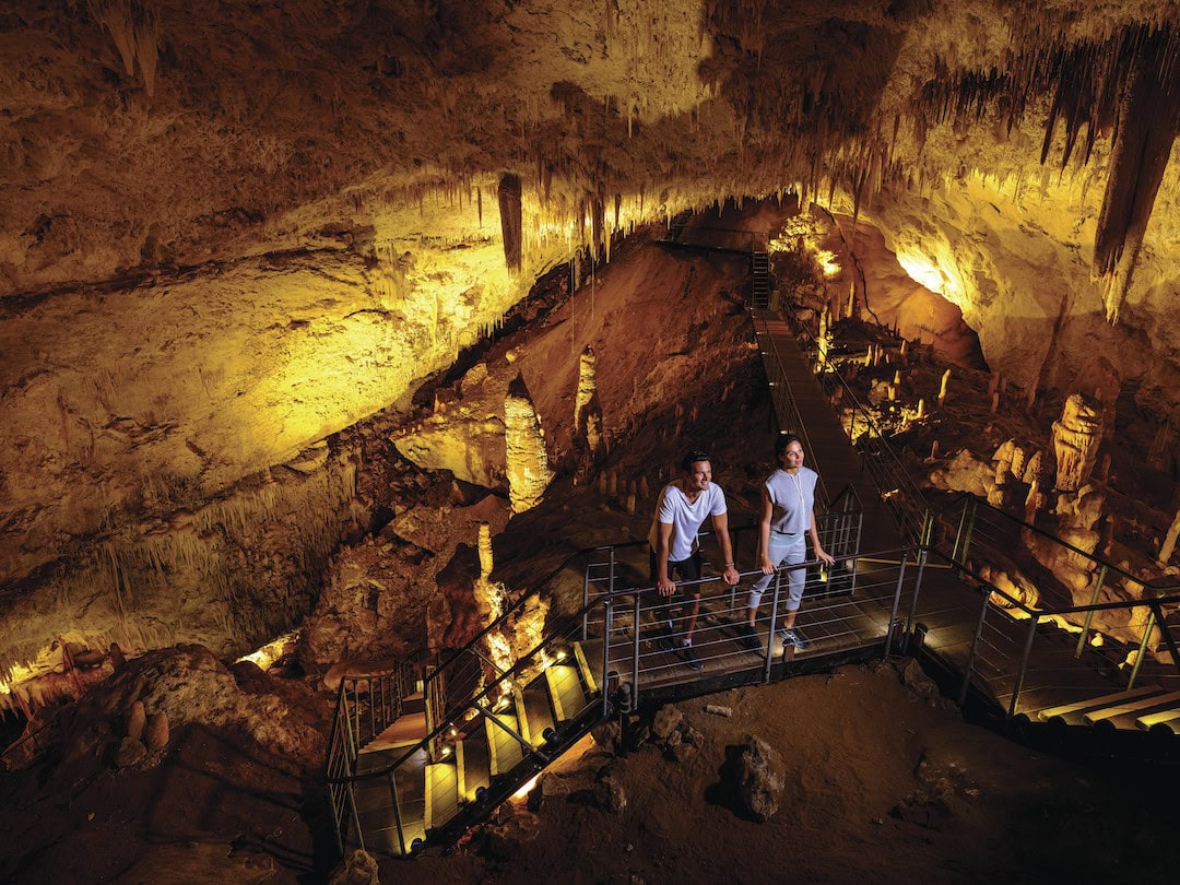 A couple exploring Jewel Cave, one of the best caves in Western Australia. Image: Tourism Western Australia.