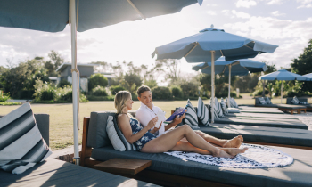 Couple relaxing at the Botanica Beach Club, exclusive to guests staying at Elements of Byron Resort, Byron Bay.